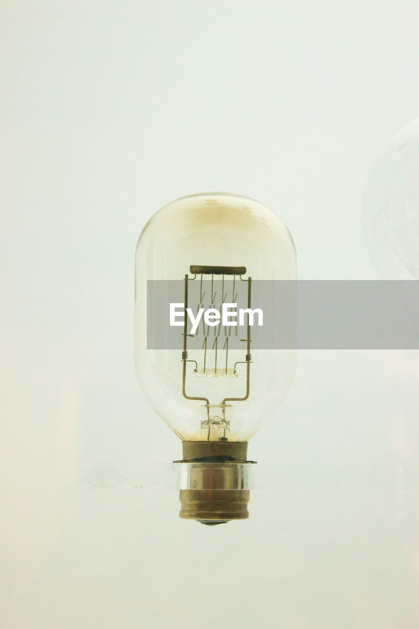 Vintage light bulb on cream white minimal background