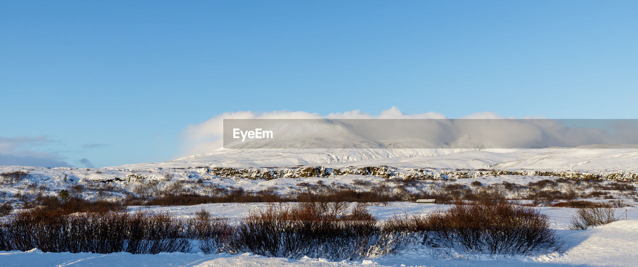 Scenic view of snowcapped mountains against clear blue sky