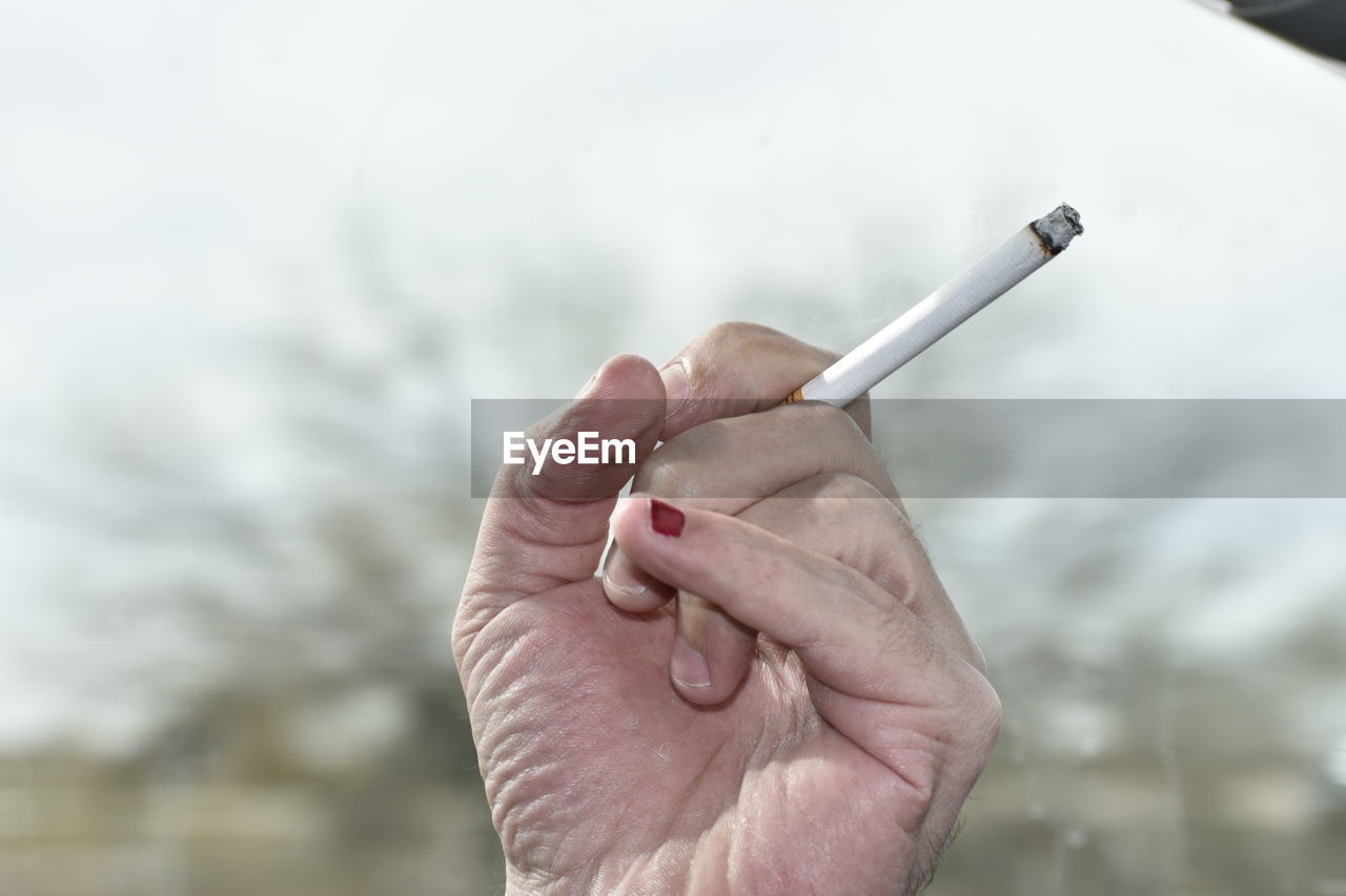 Cropped hand of woman holding cigarette