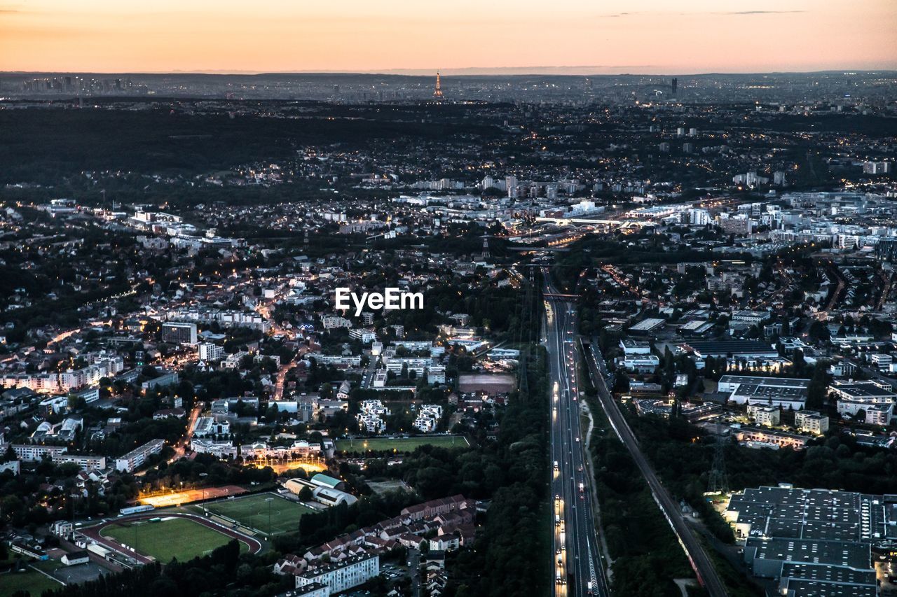 High angle view of illuminated city against sky at dusk