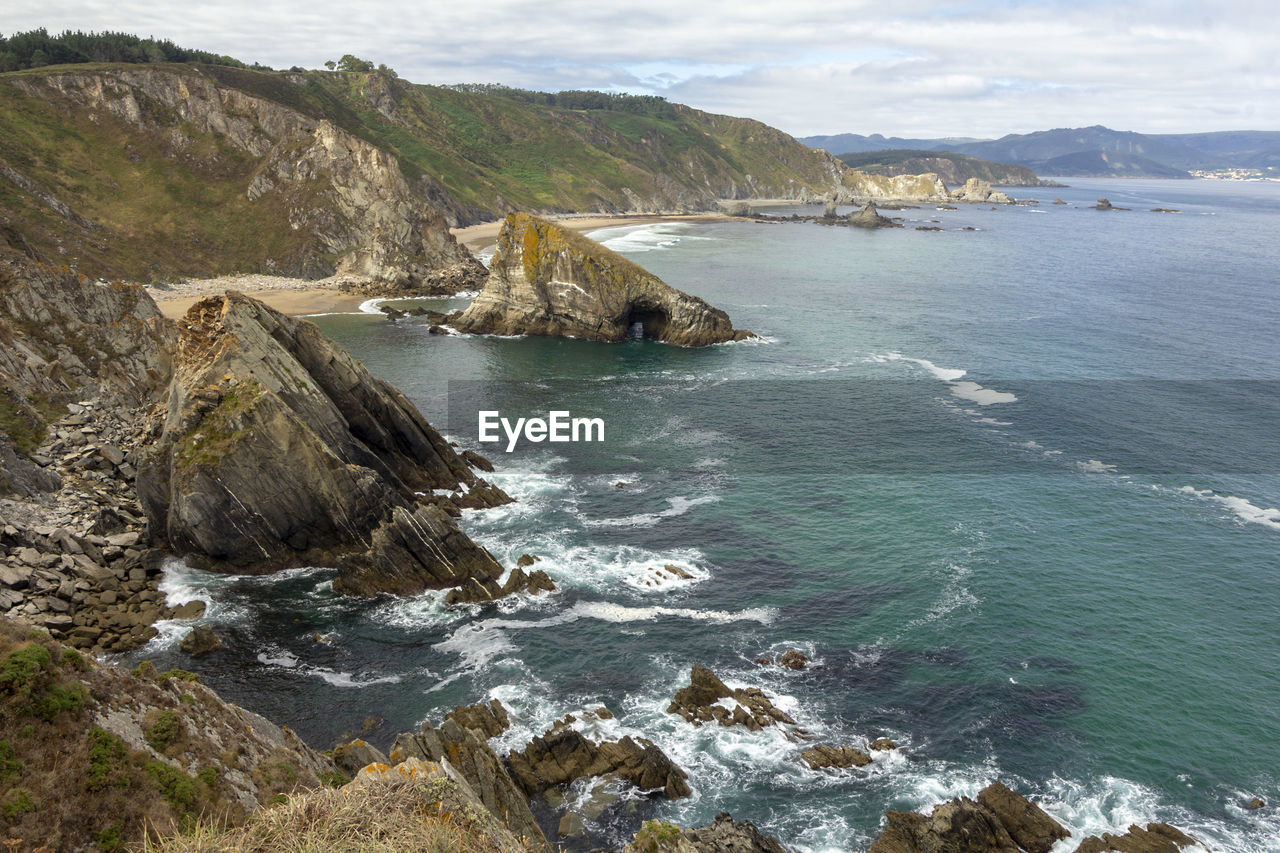 Scenic view of sea and mountains against sky