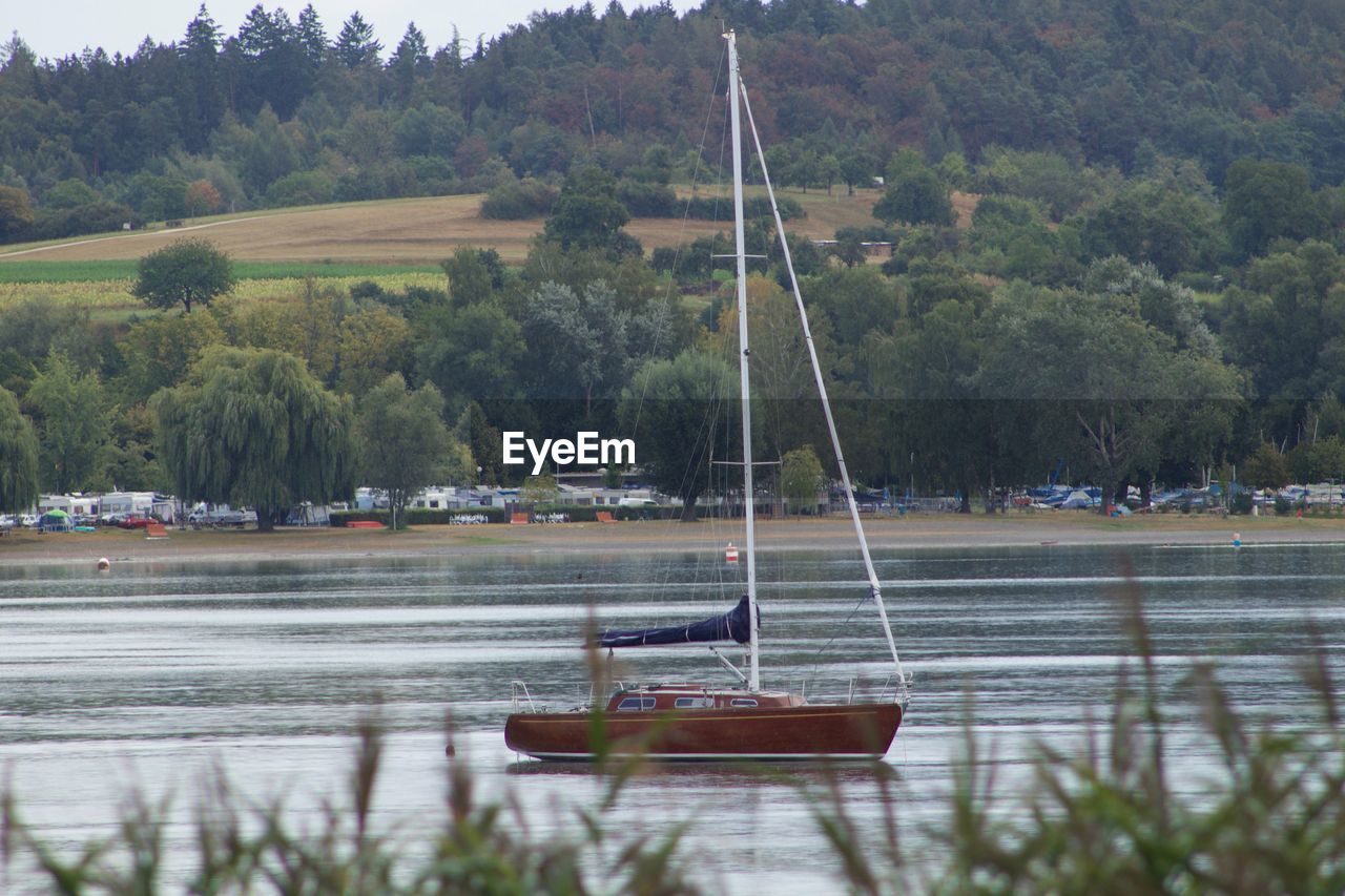 SAILBOATS MOORED ON LAKE
