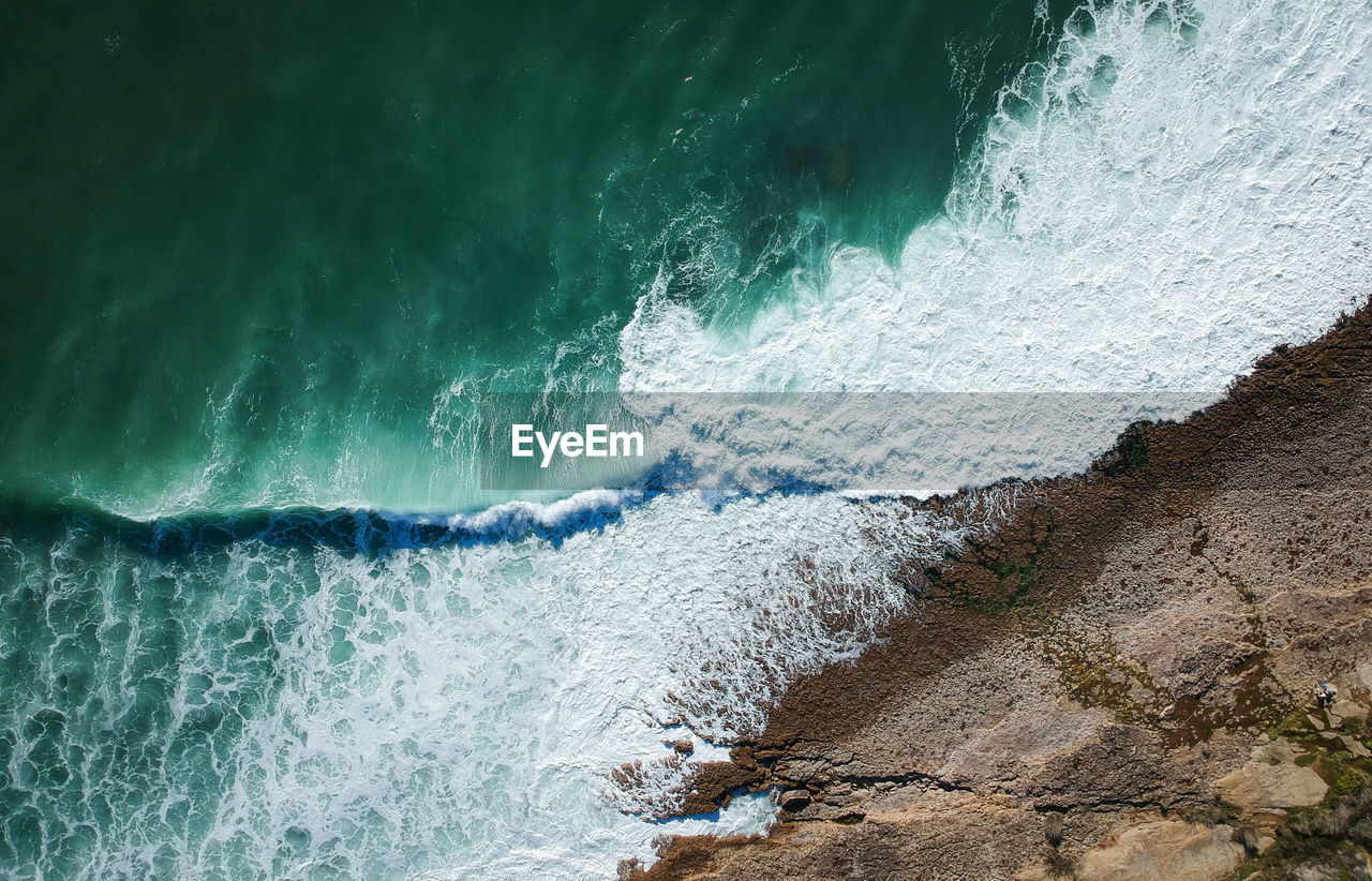 Aerial view of waves splashing on rocks