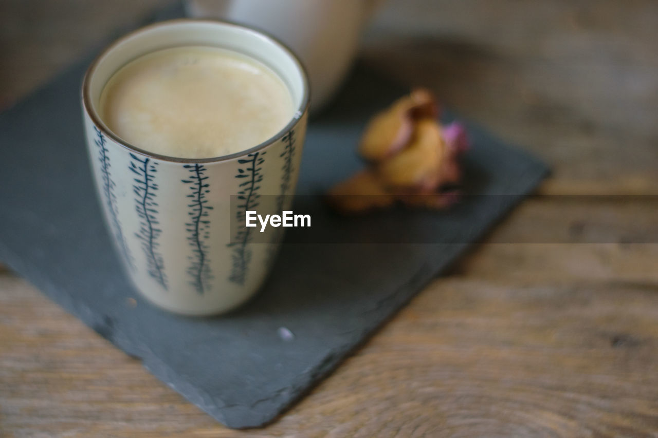 CLOSE-UP OF COFFEE IN GLASS ON TABLE