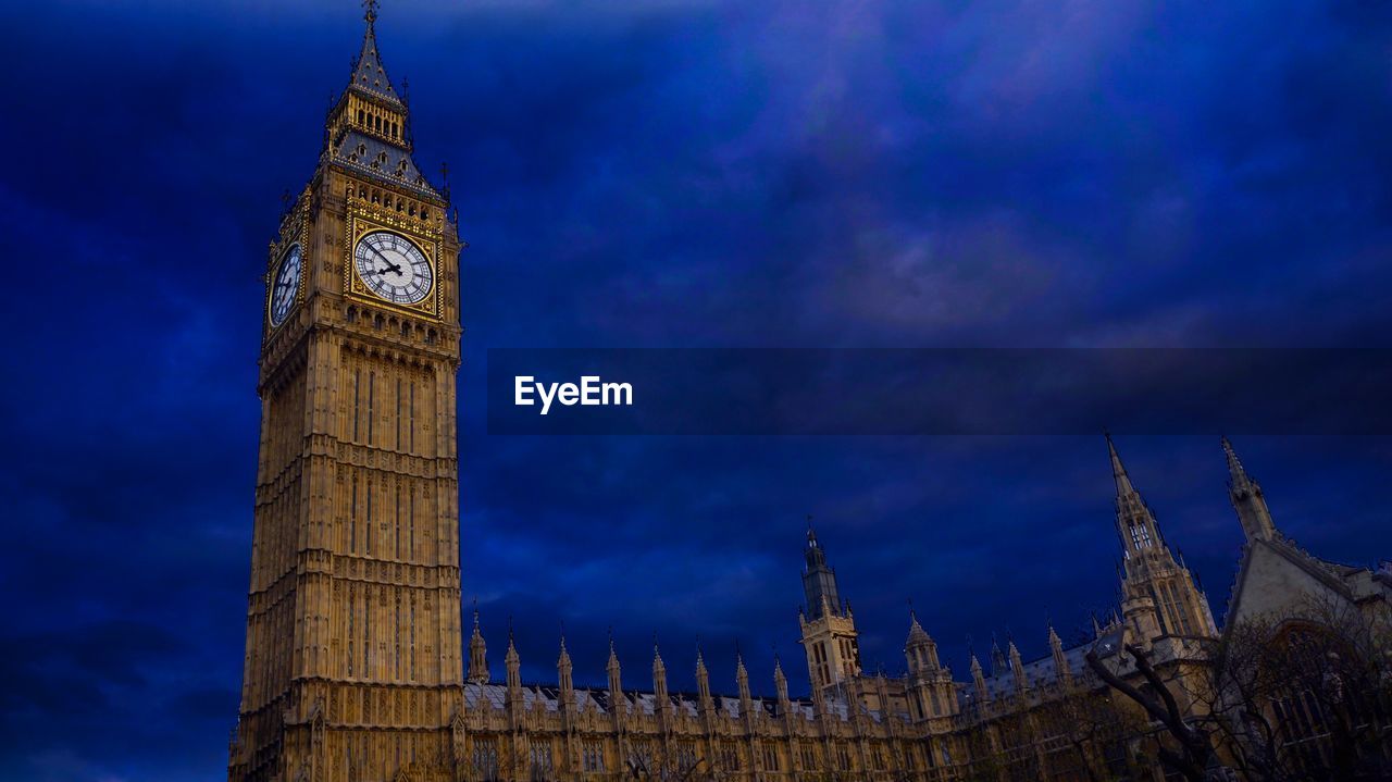 Low angle view of big ben against blue cloudy sky