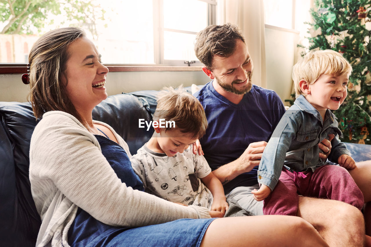 Cheerful family sitting on sofa at home