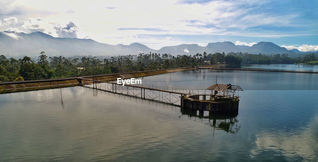 SCENIC VIEW OF LAKE BY MOUNTAIN AGAINST SKY