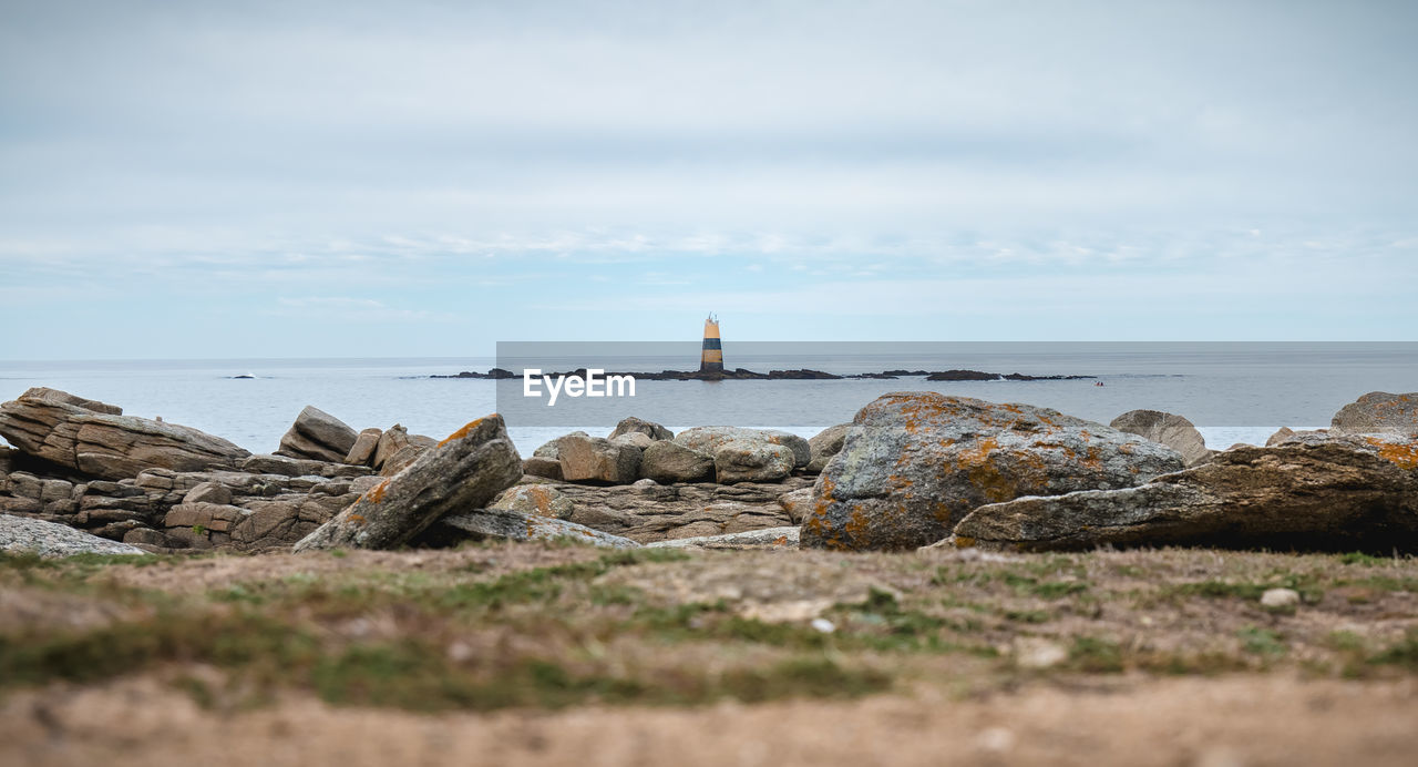 ROCKS ON SHORE AGAINST SKY