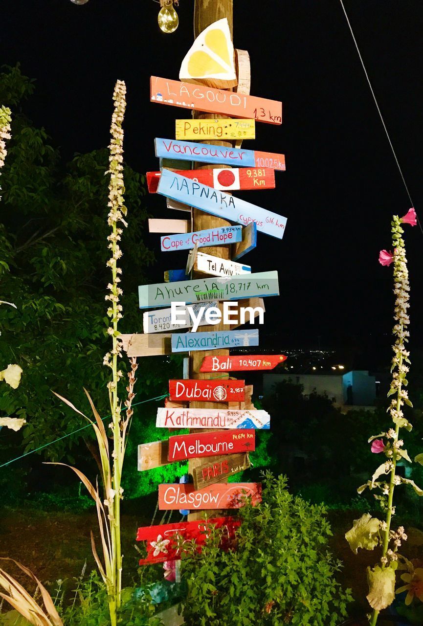 CLOSE-UP OF INFORMATION SIGN HANGING AT NIGHT