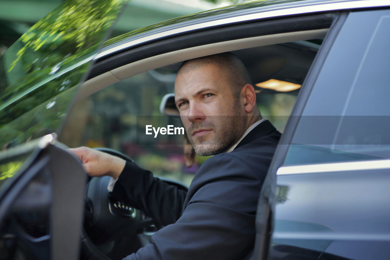 Confident businessman looking away while sitting in car