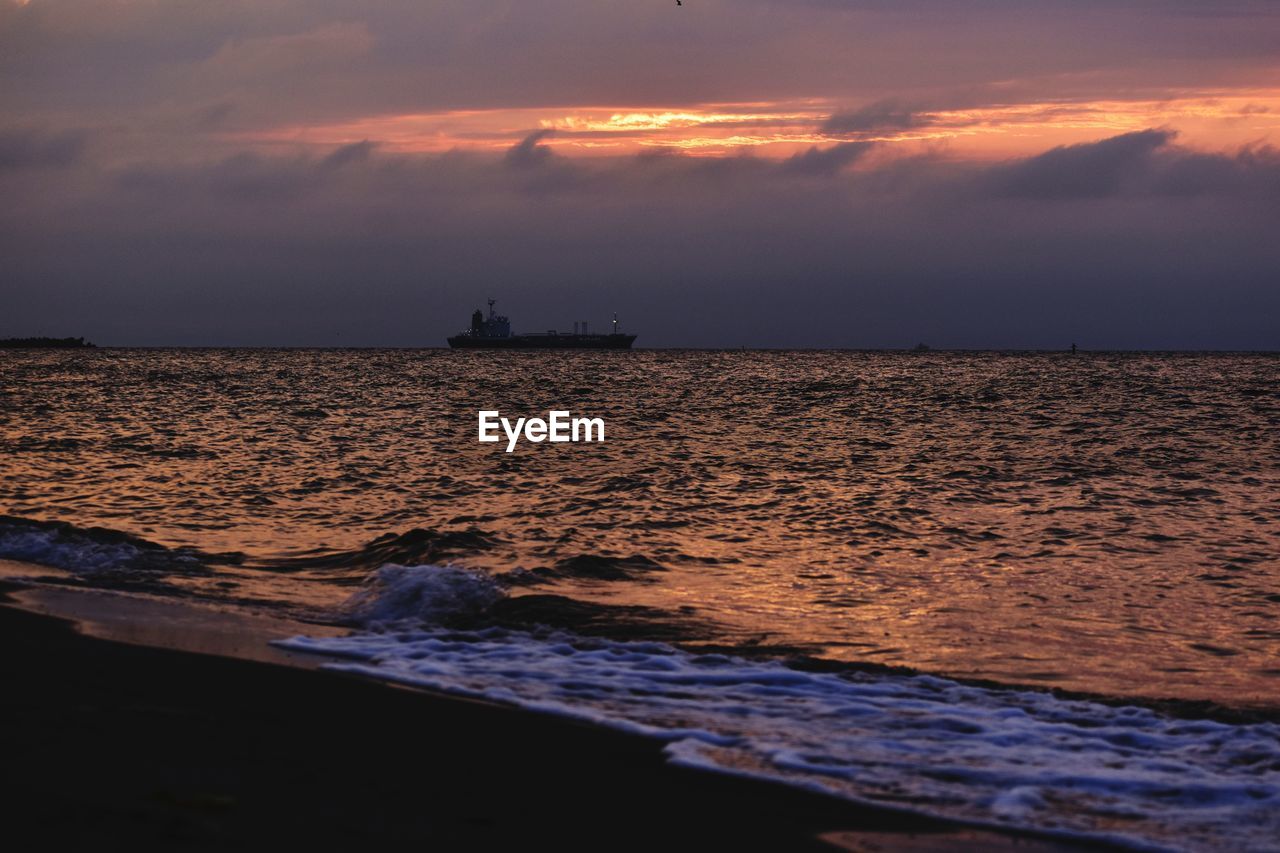 SCENIC VIEW OF BEACH AGAINST SKY DURING SUNSET