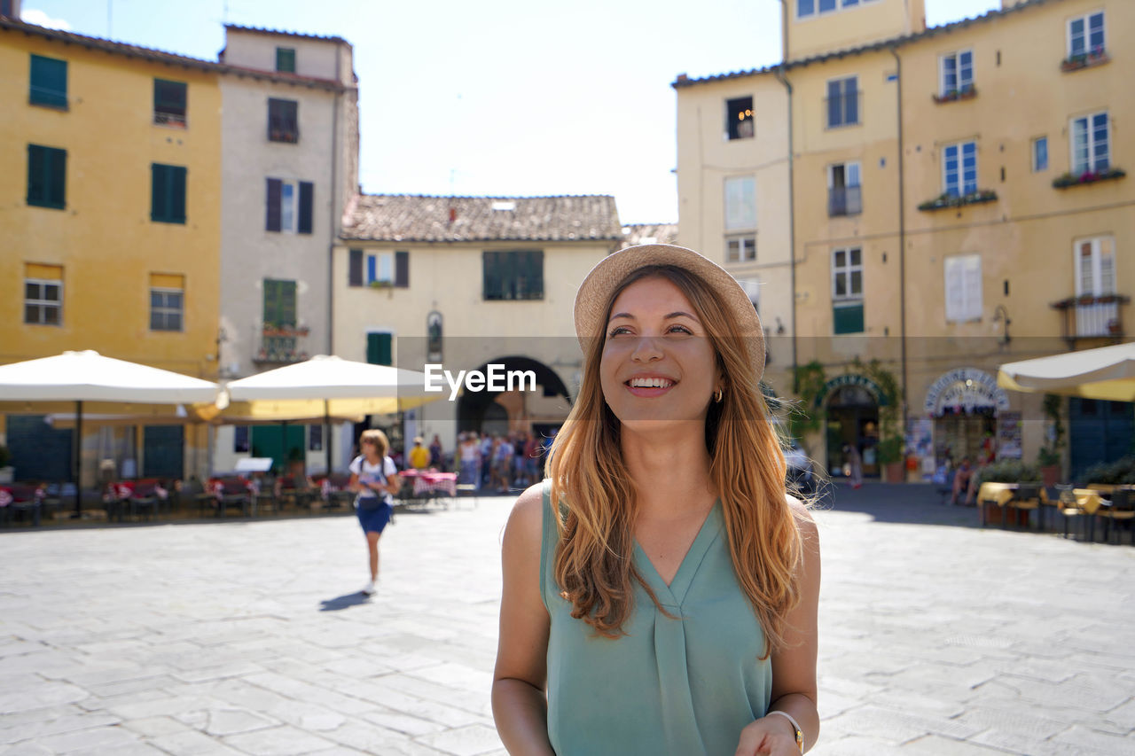 Discovering italy. cheerful young woman visiting the historic city of lucca, tuscany, italy.