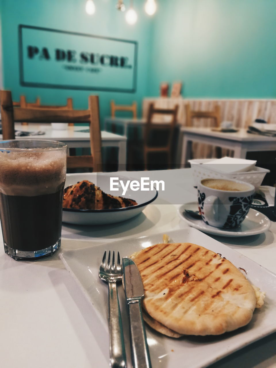 HIGH ANGLE VIEW OF COFFEE AND DRINK IN GLASS ON TABLE