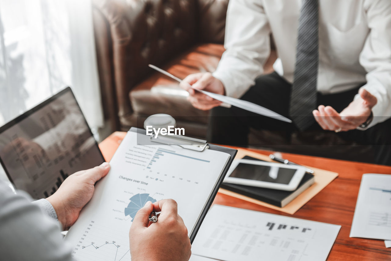 Cropped image of business colleagues working at desk in office