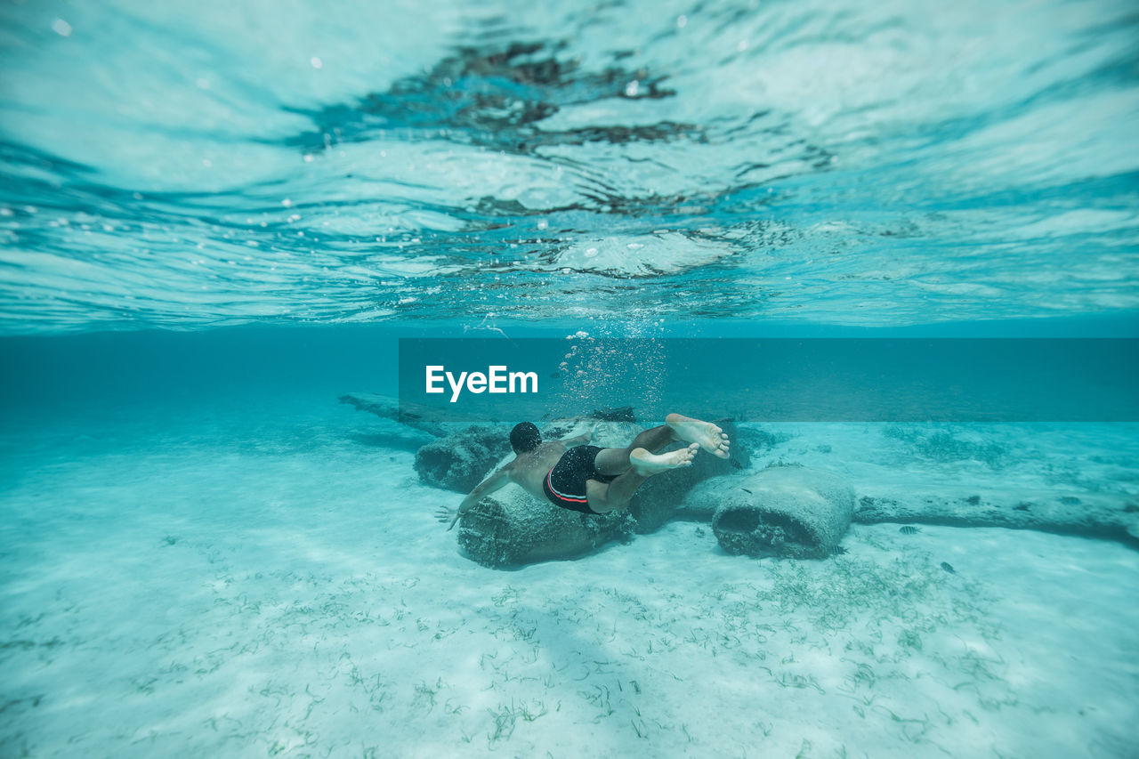 Full length of man swimming undersea