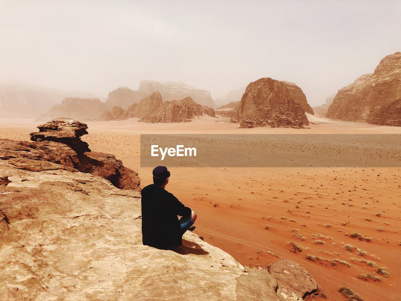 REAR VIEW OF MAN LOOKING AT MOUNTAINS