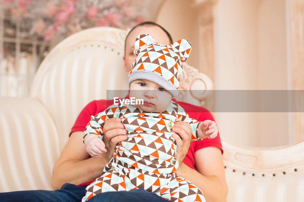 Portrait of cute baby girl sitting at home