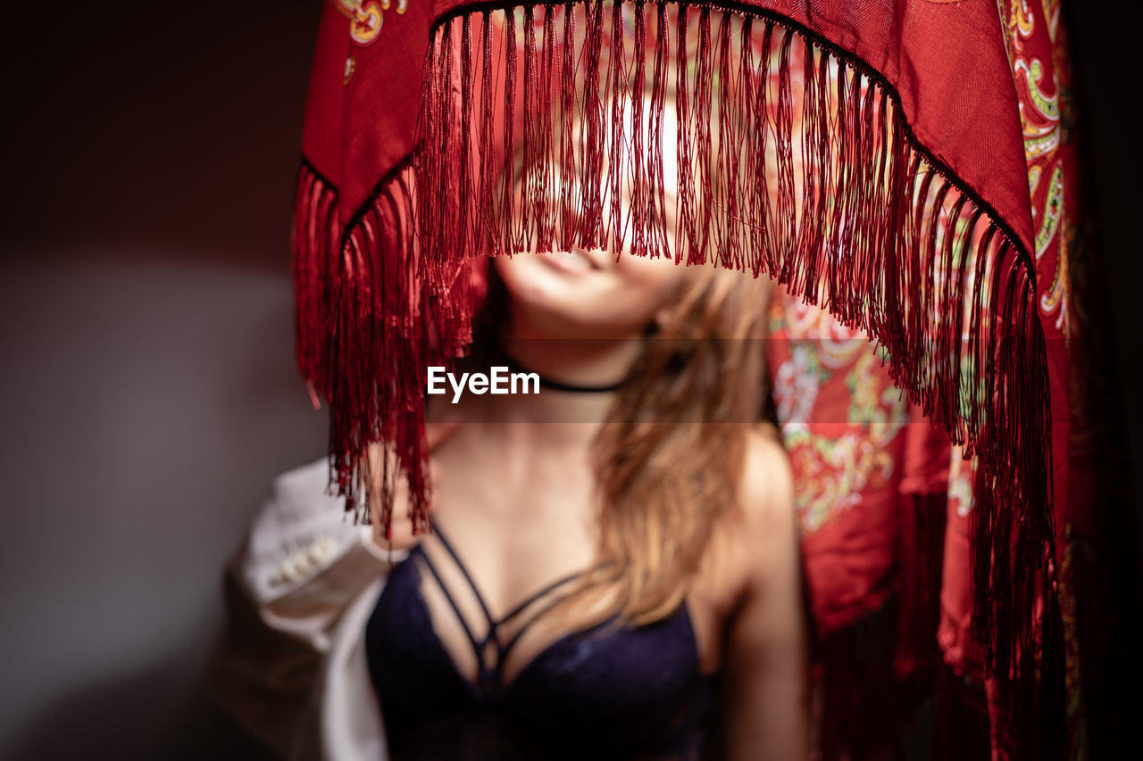 Woman in lingerie standing under covered lighting equipment