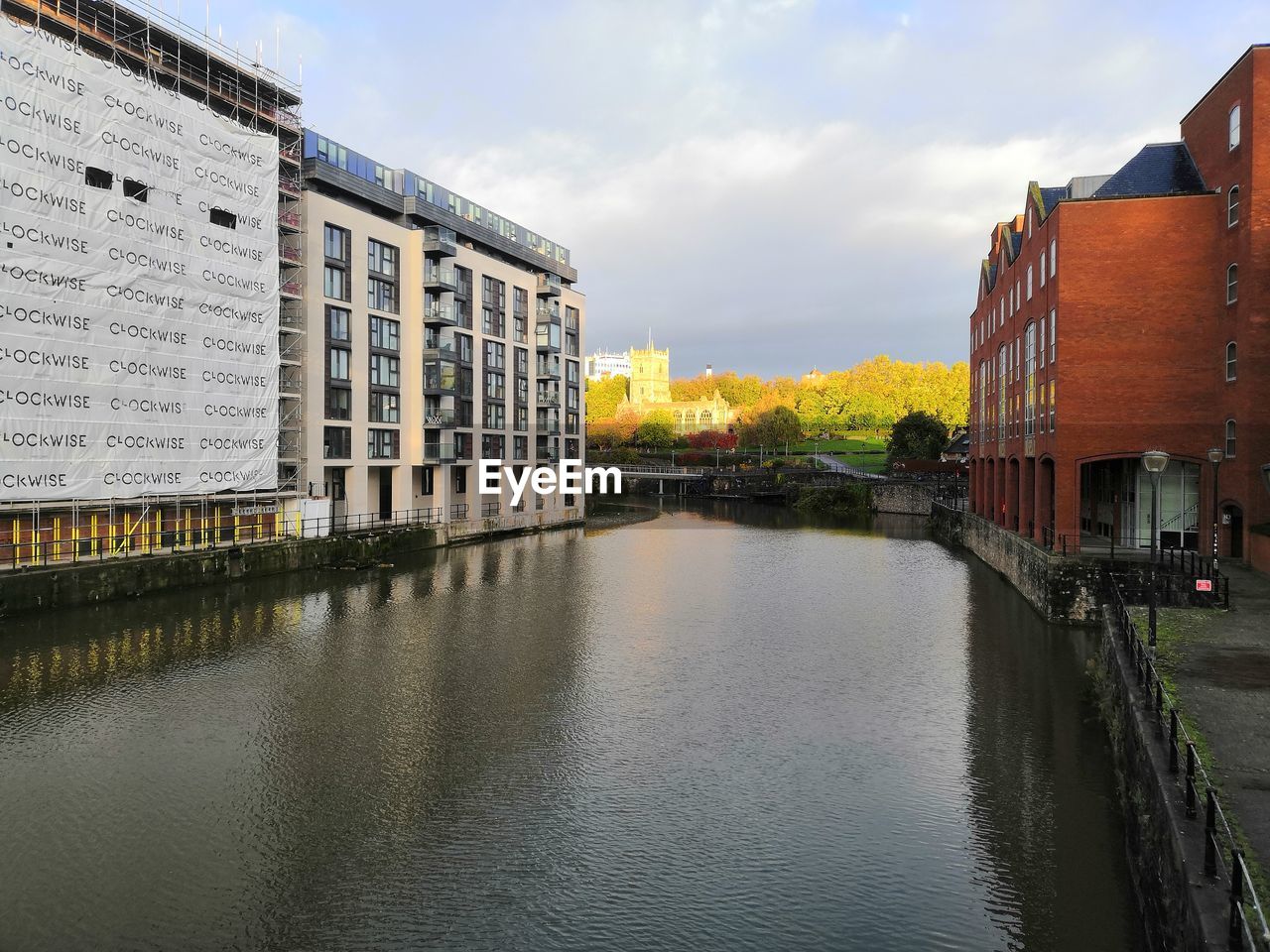 RIVER BY BUILDINGS AGAINST SKY