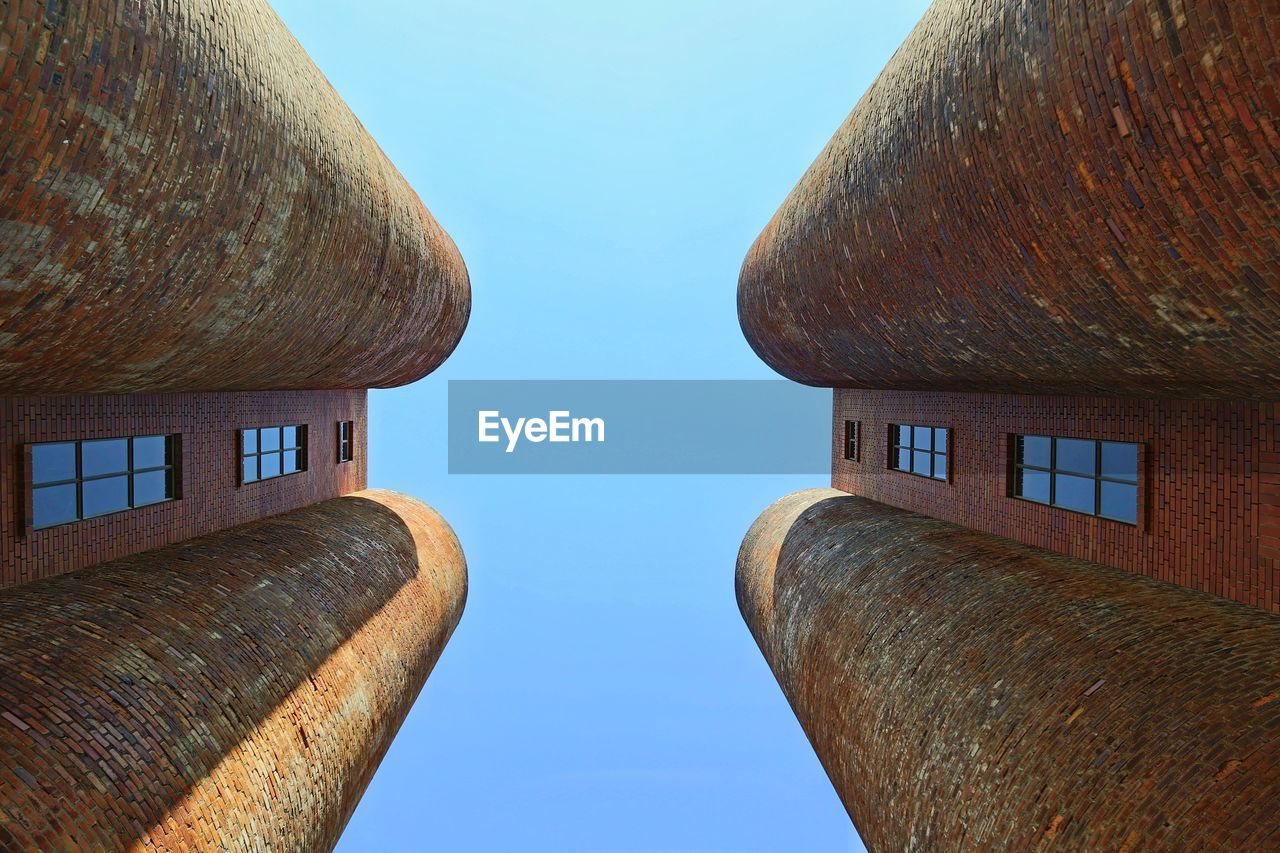 Low angle view of buildings against clear blue sky