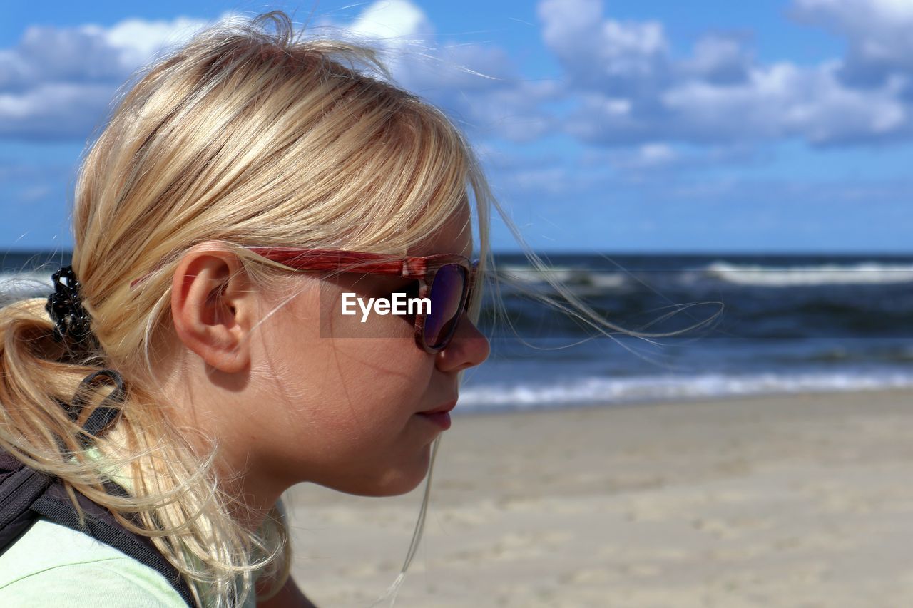 Close-up of cute girl looking away at beach