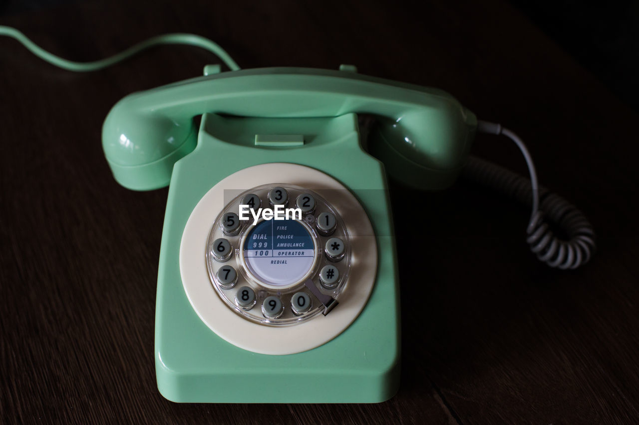 High angle view of rotary phone on wooden table