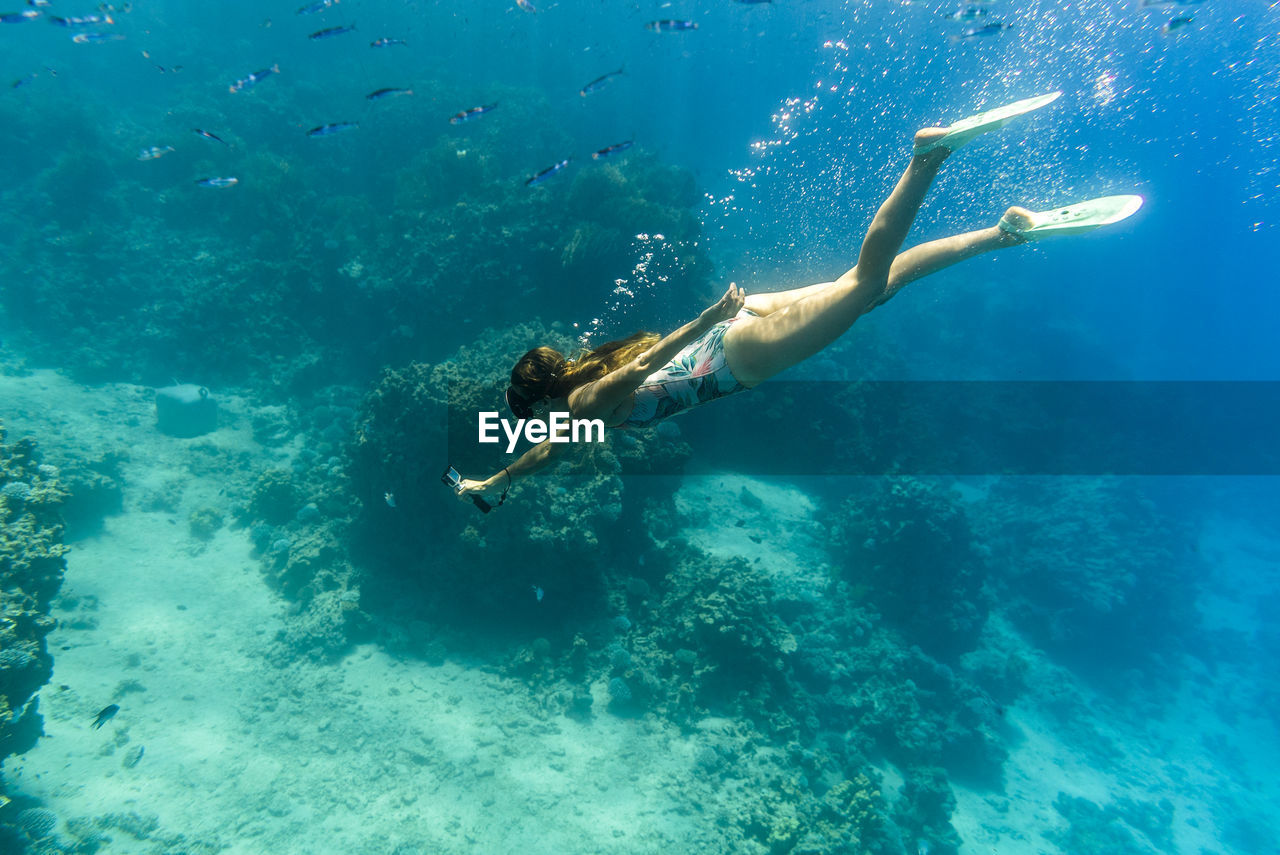 Woman photographing in sea