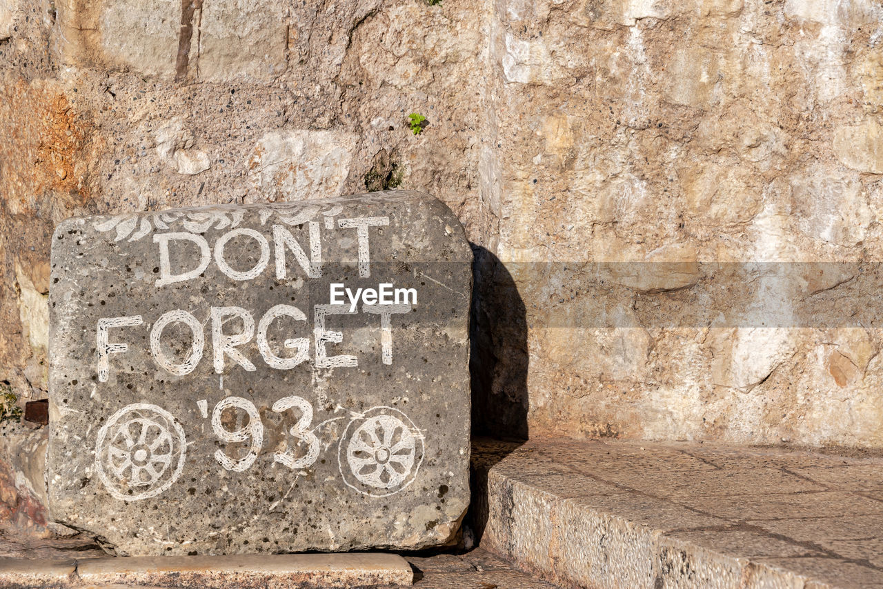 TEXT ON STONE WALL