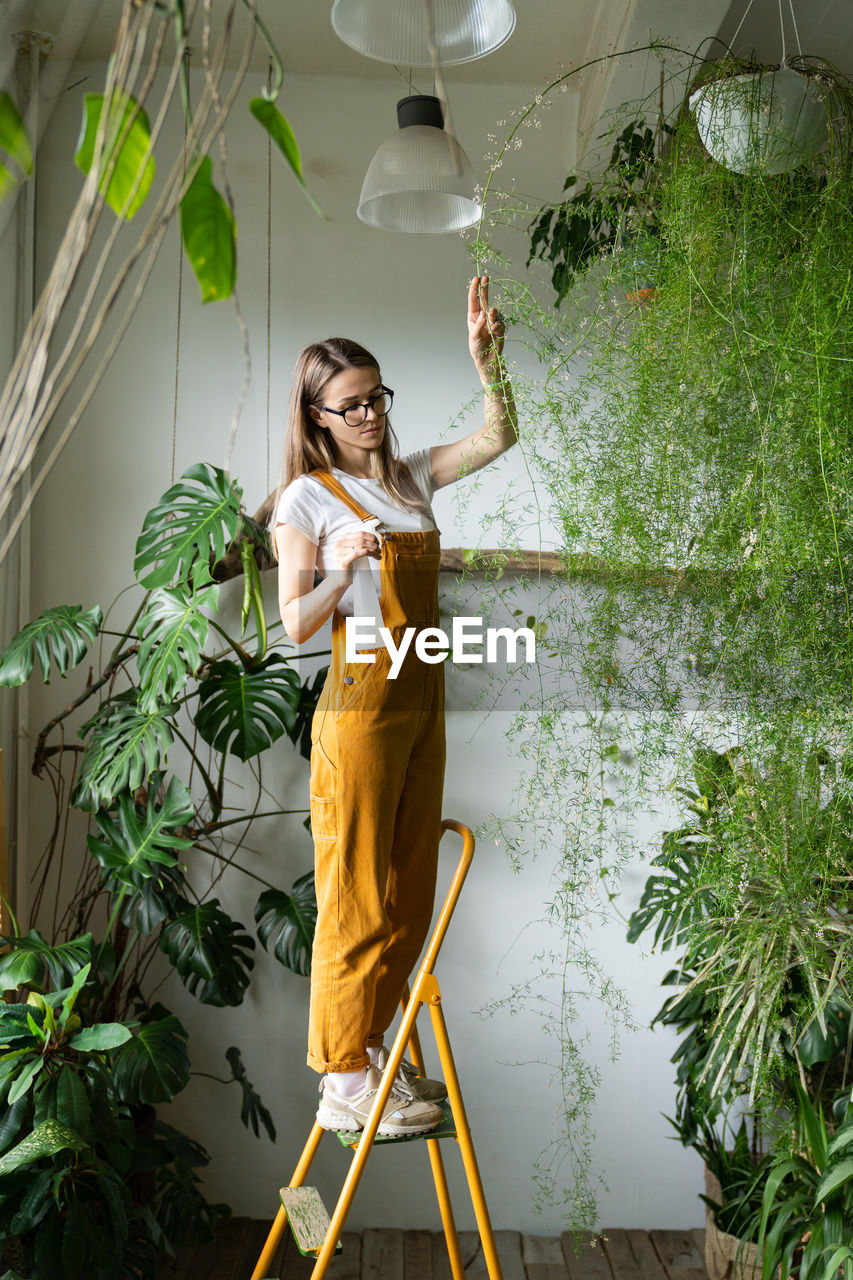 Young woman by potted plants