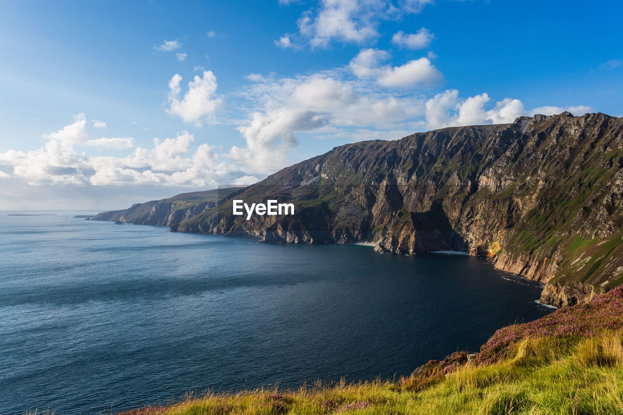 Scenic view of sea and mountains against sky