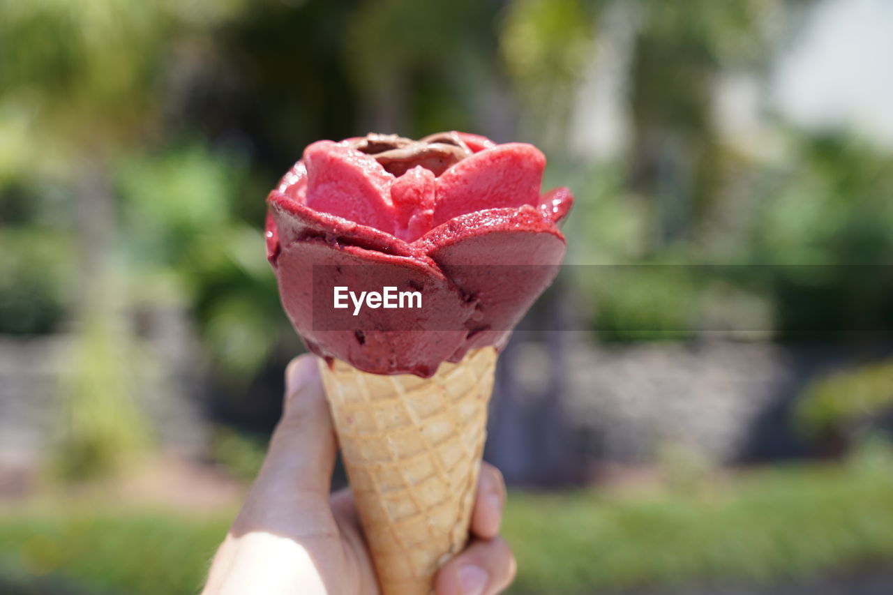 CLOSE-UP OF HAND HOLDING ICE CREAM CONE DURING WINTER