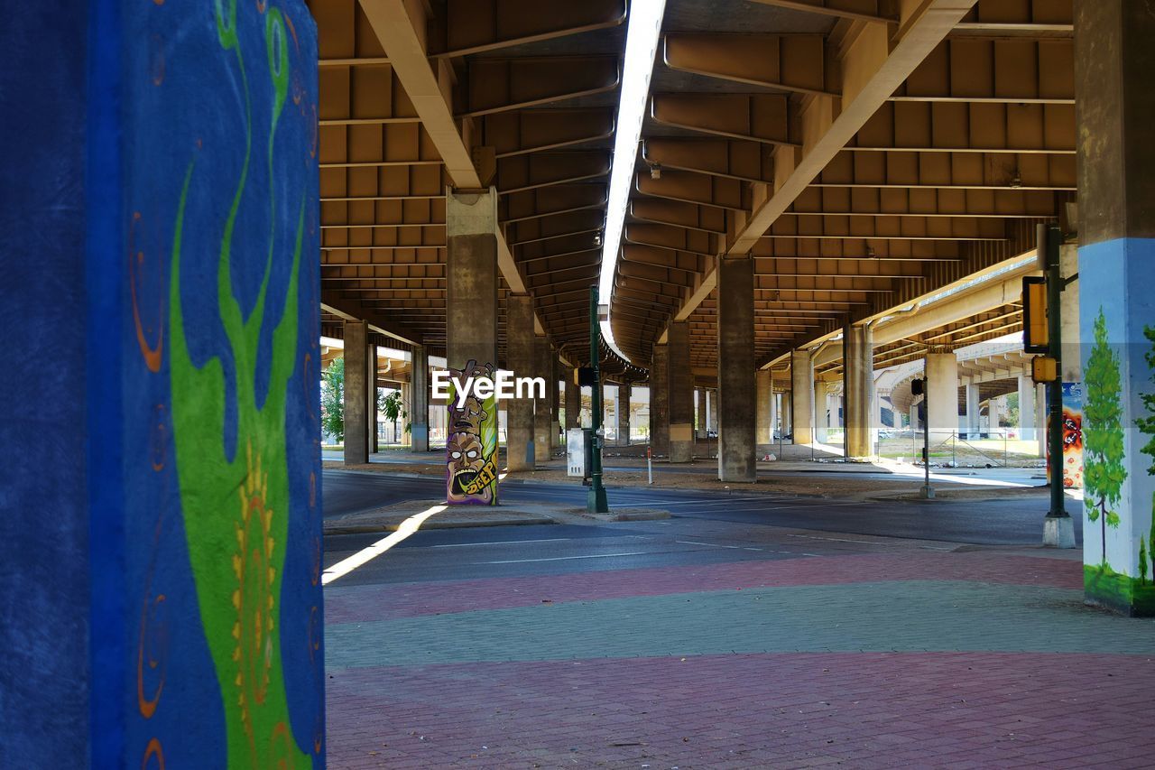 Multi colored road and graffiti columns below bridge