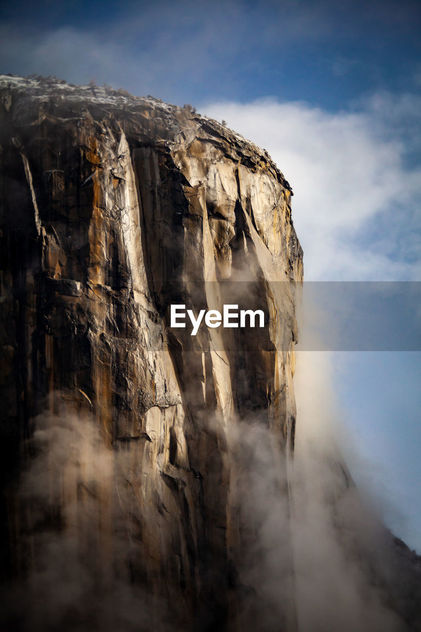 ROCK FORMATIONS ON CLIFF AGAINST SKY