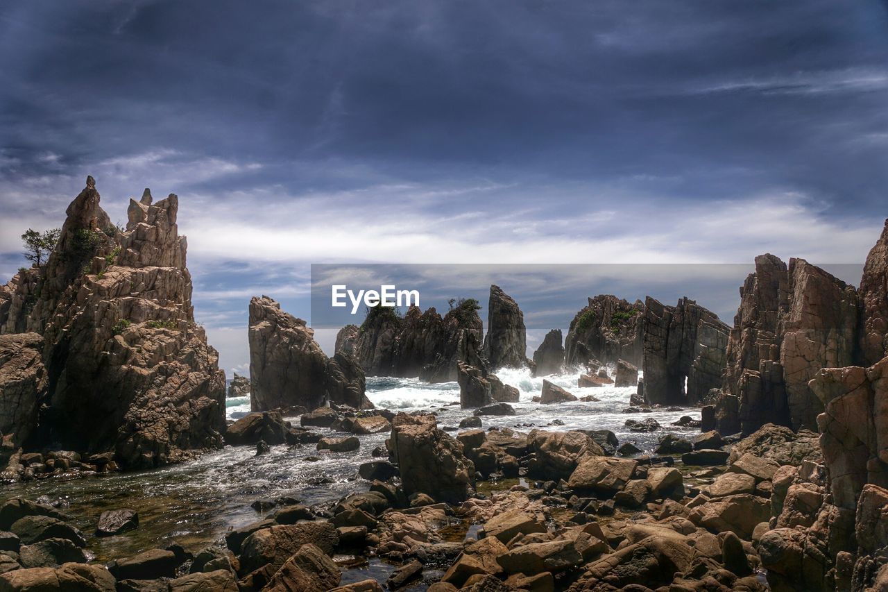 Rocks on beach against sky