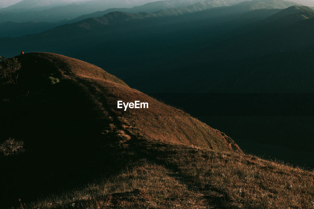 Scenic view of land and mountains against sky