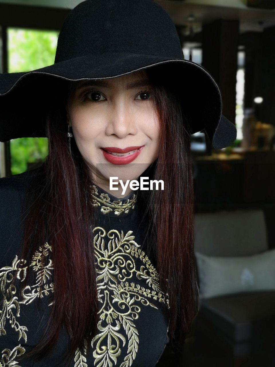 Close-up portrait of smiling young woman with hat