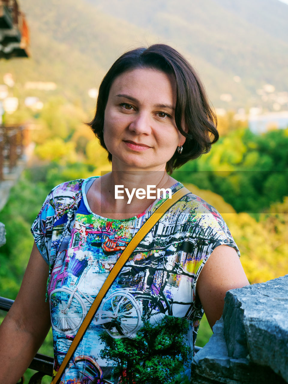 Adult woman close-up portrait on blurred foliage background