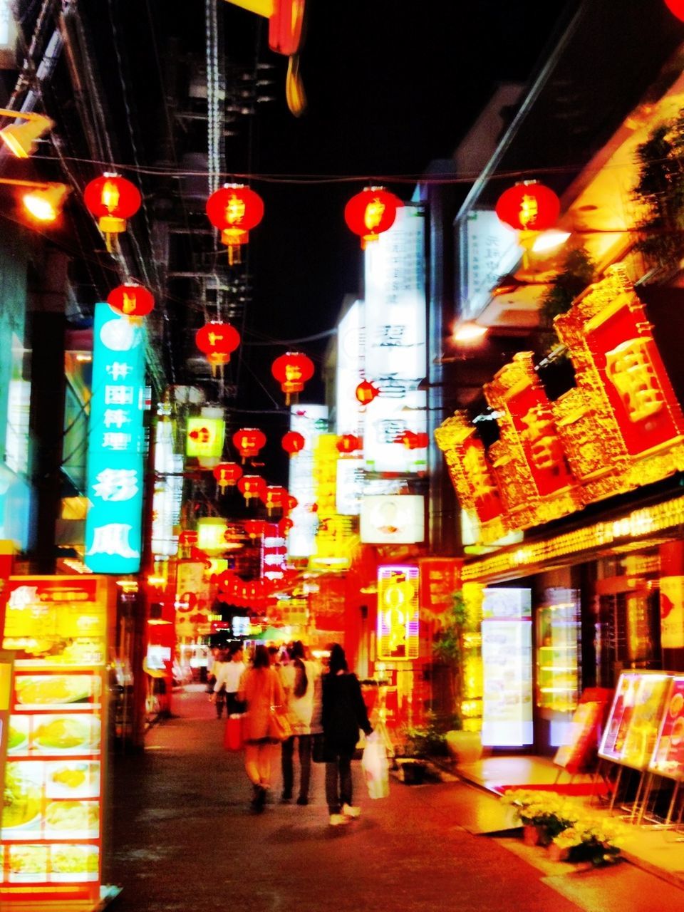 WOMAN STANDING IN ILLUMINATED CITY AT NIGHT