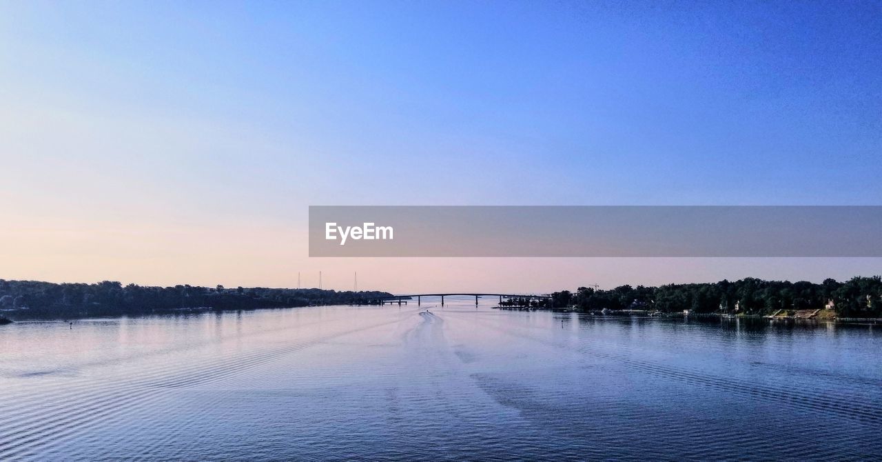 SCENIC VIEW OF LAKE AGAINST SKY AT SUNSET