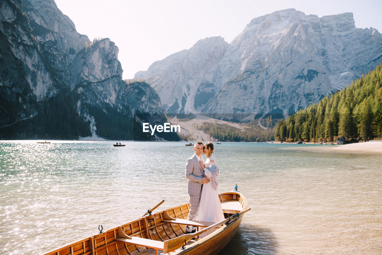 PEOPLE ON LAKE BY MOUNTAINS