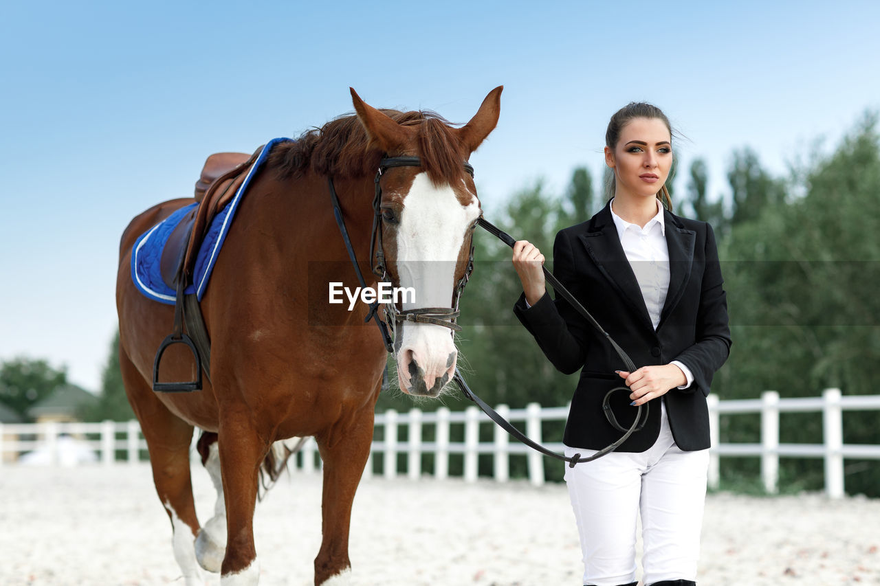 full length of man riding horse on field against clear sky