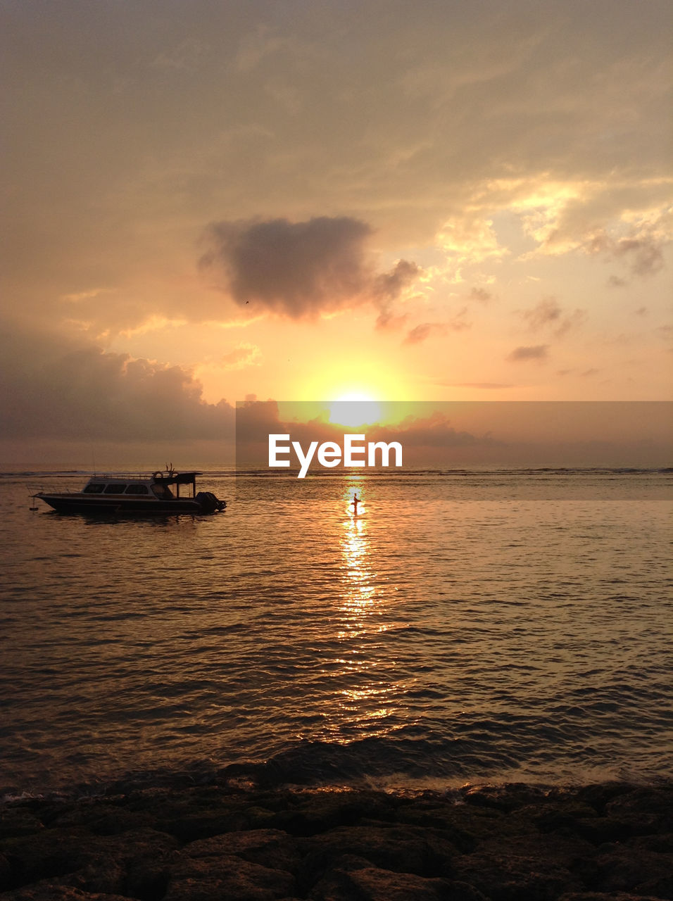 Lone boat in calm sea against scenic sky