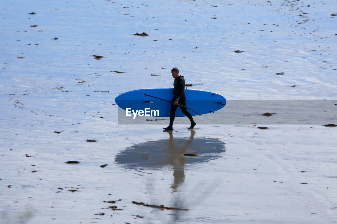 HIGH ANGLE VIEW OF MAN SURFING