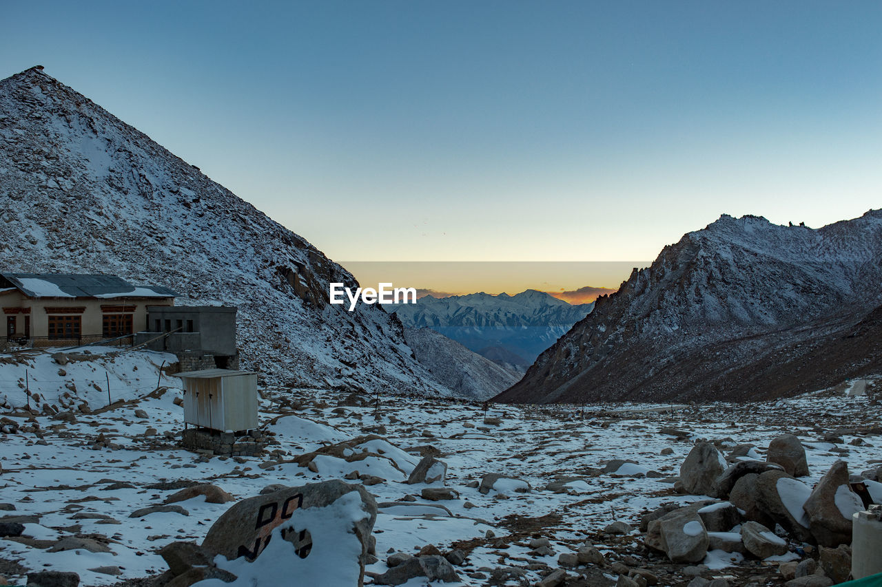 Scenic view of snowcapped mountains against clear sky during winter