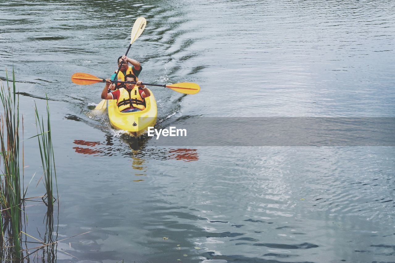 REAR VIEW OF PERSON FLOATING IN LAKE