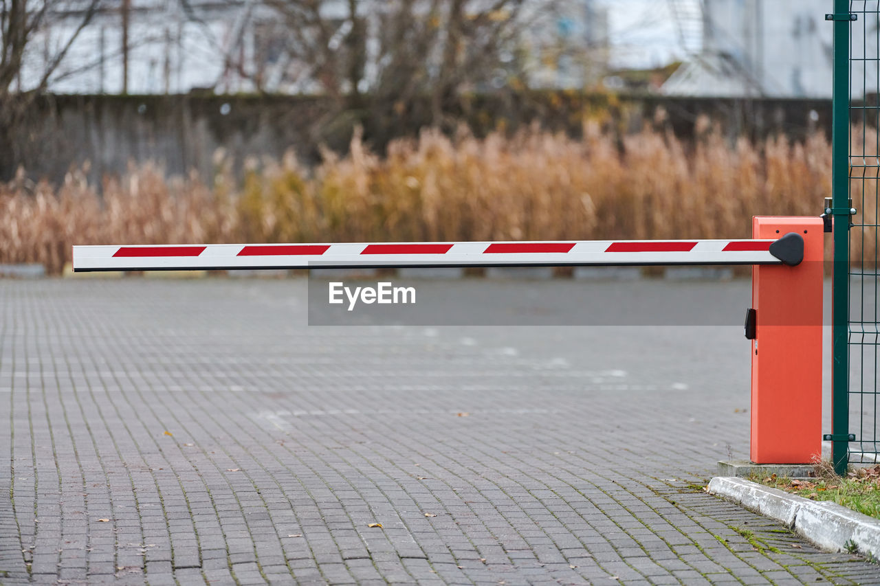 Parking gate, automatic car barrier system for car-park security. white red boom gate.