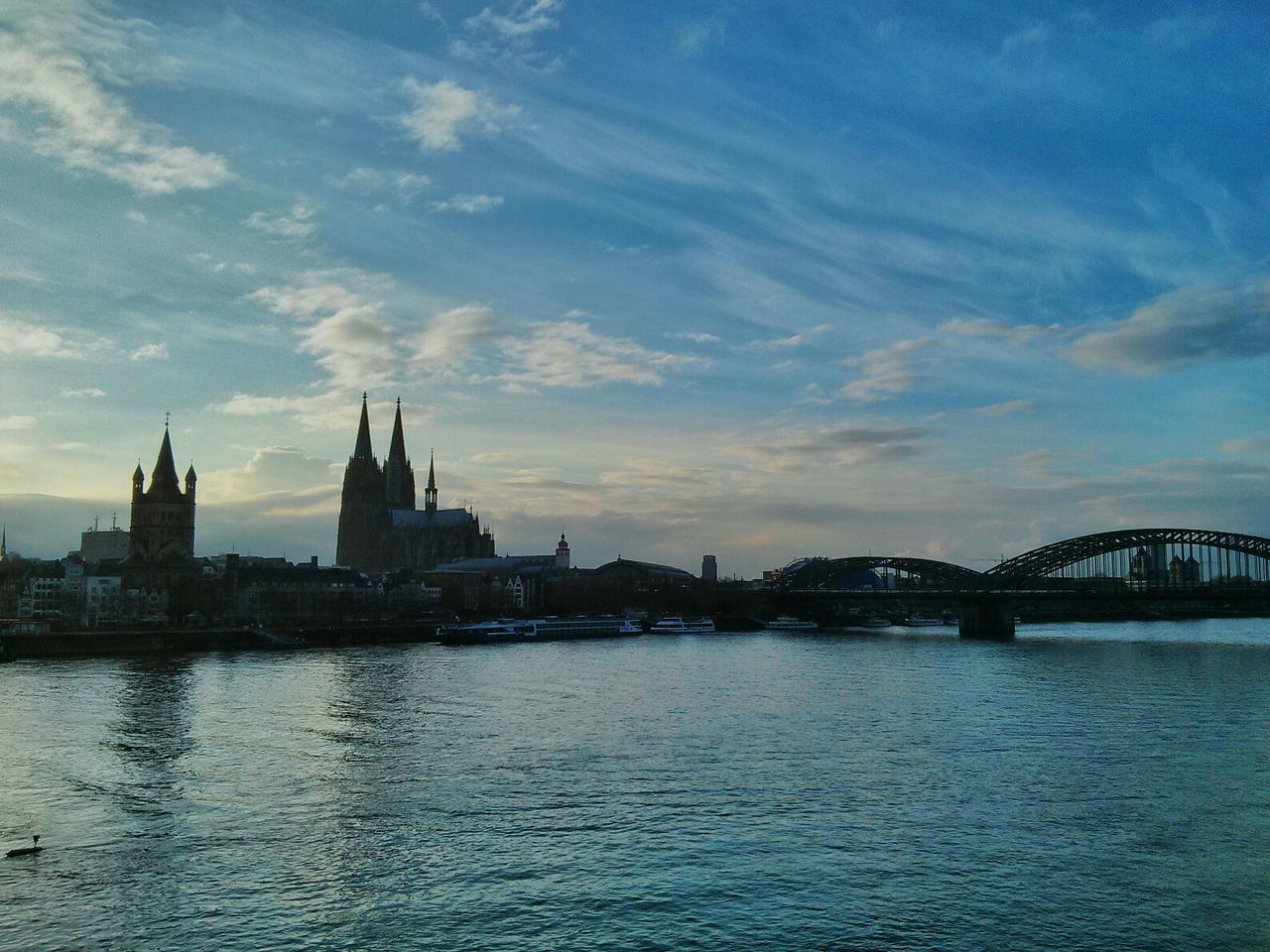 BRIDGE OVER RIVER WITH CITY IN BACKGROUND