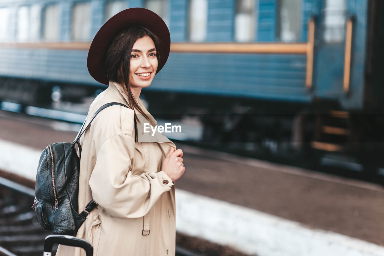 Portrait of young beautiful woman traveler who is waiting train