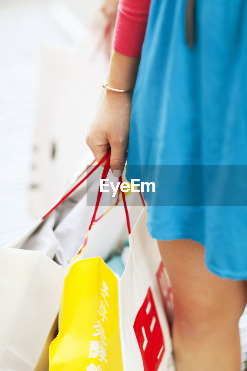 Womans hand holding shopping bags