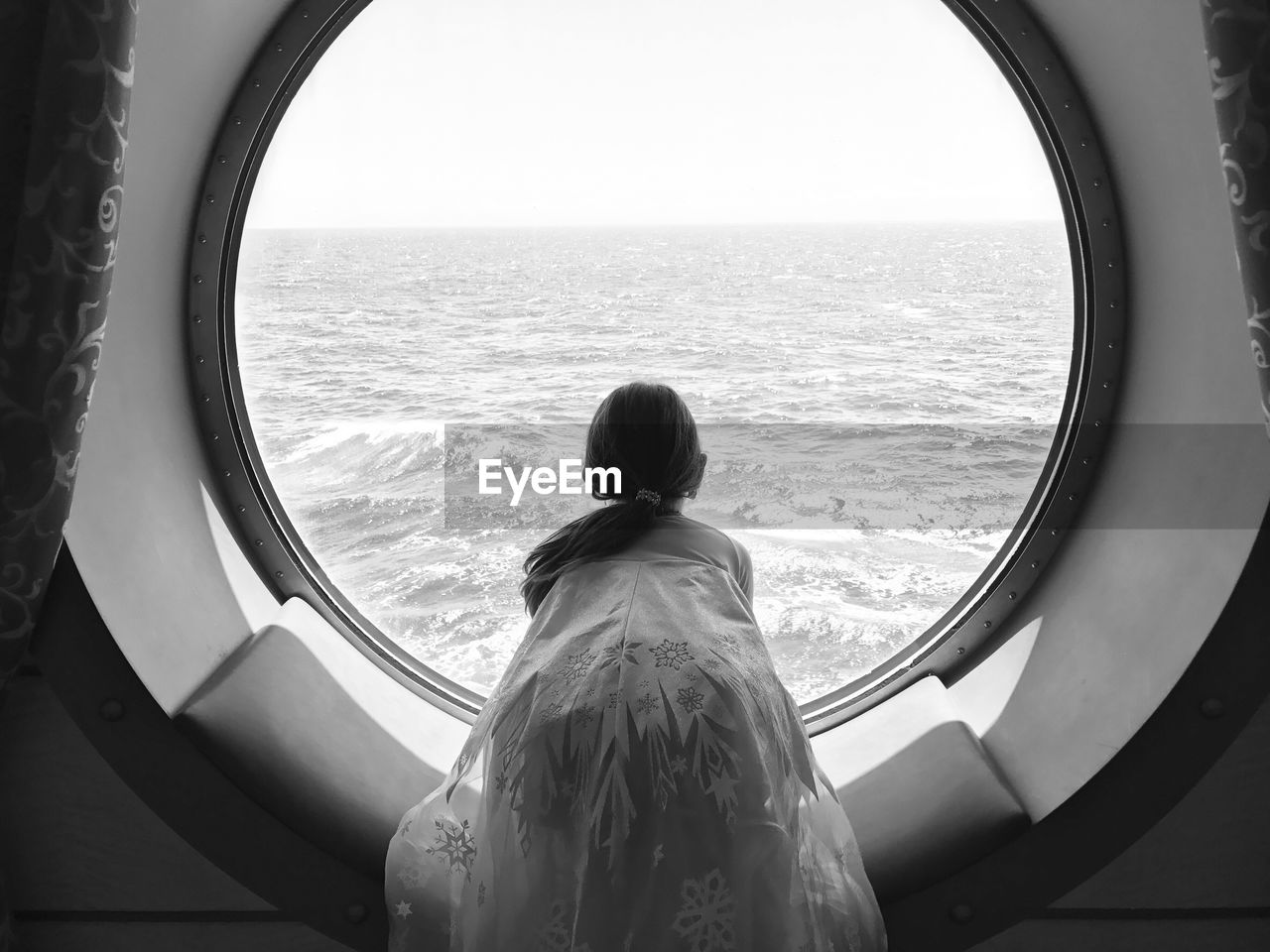 Rear view of girl looking at sea from tourboat